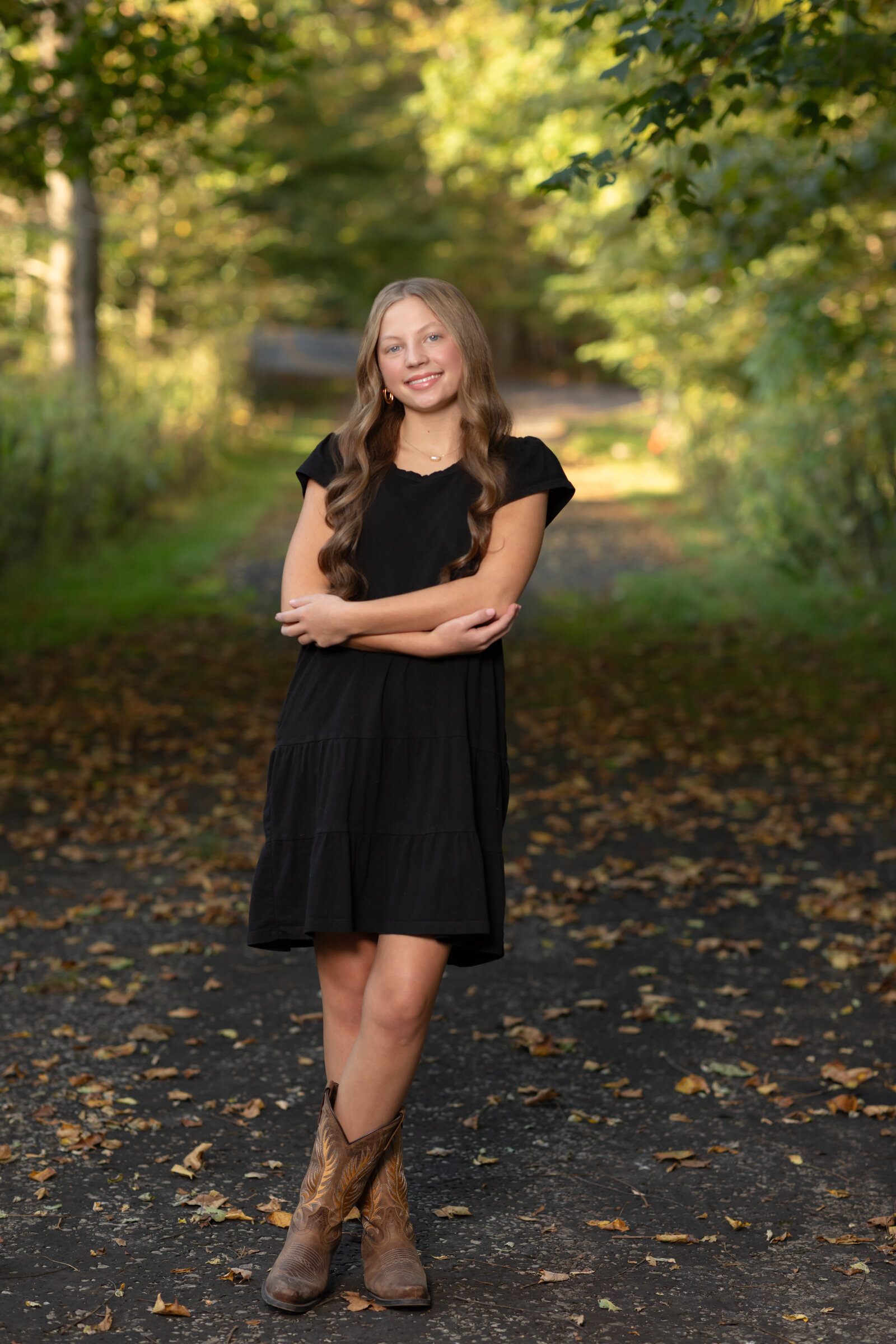 girl wearing black dress posing in park for fall family photos