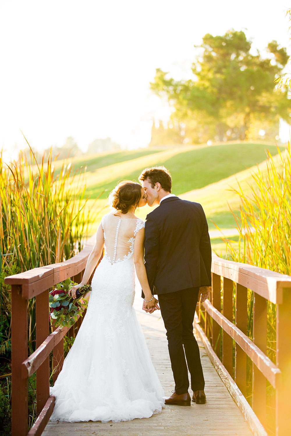 bride and groom on bridge at carlton oaks country club