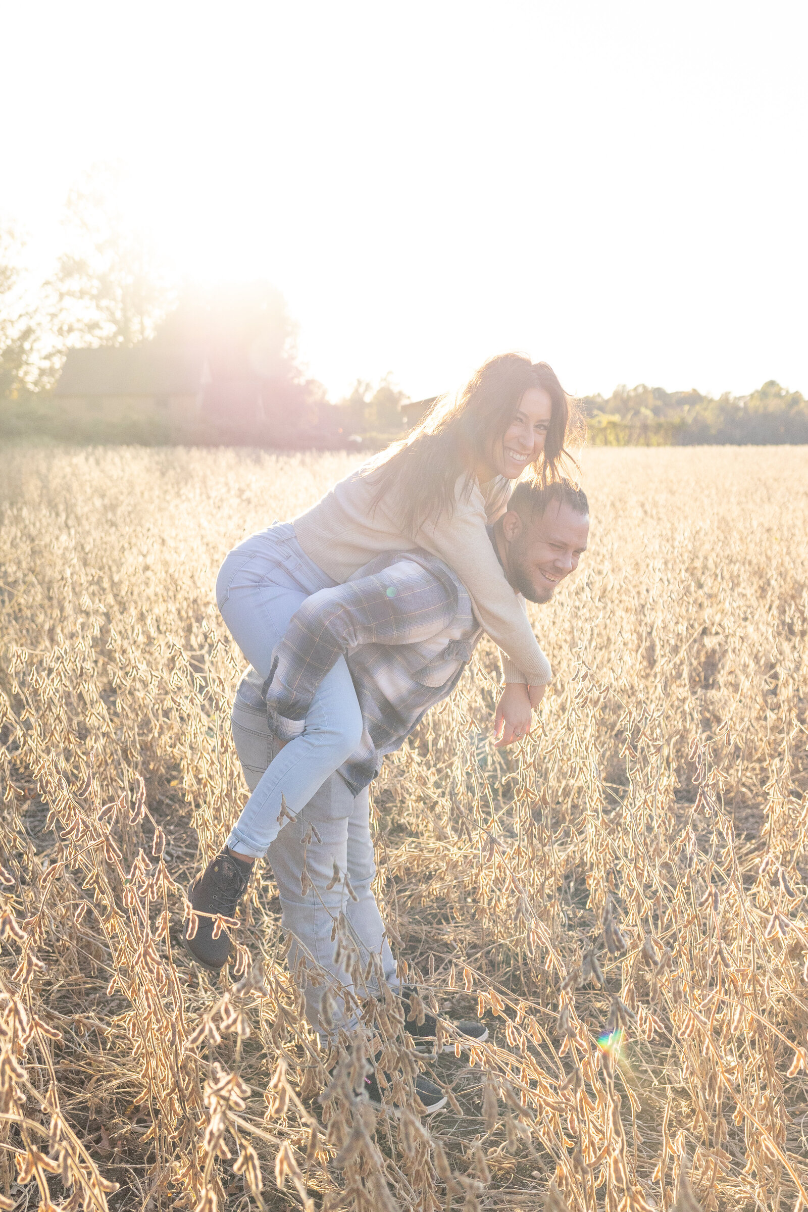 engaged couple on piggyback in tyler state park sunset wheat field