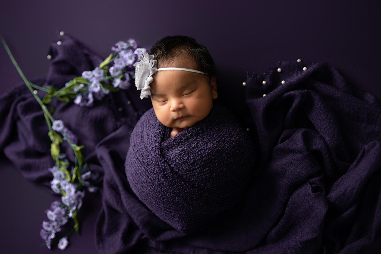 newborn baby girl wearing purple
