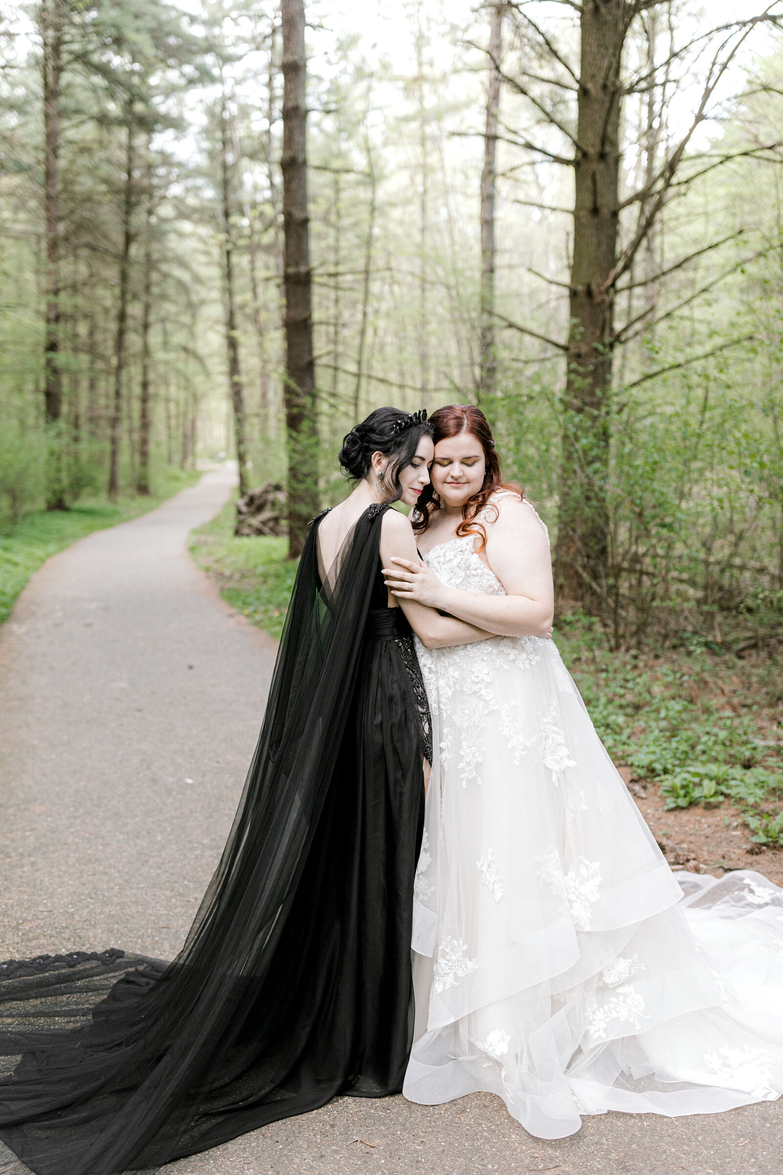 Two brides embracing in the forest