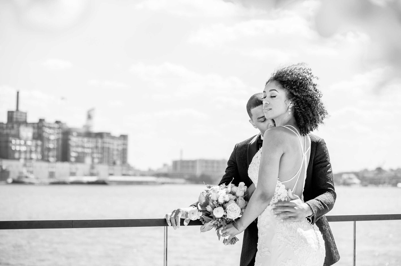A black couple poses on a wedding pier