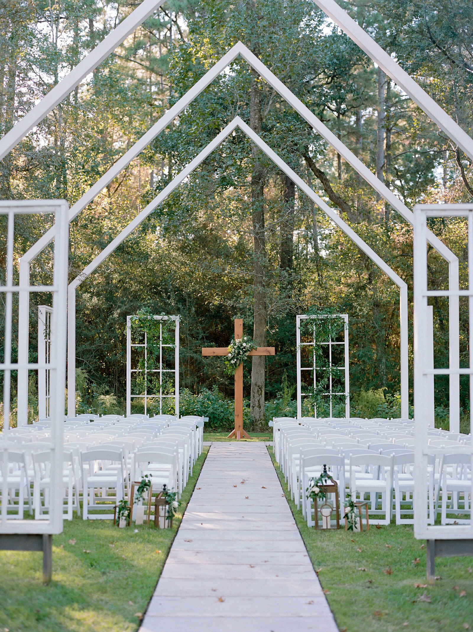 outdoor wedding ceremony with cross backdrop