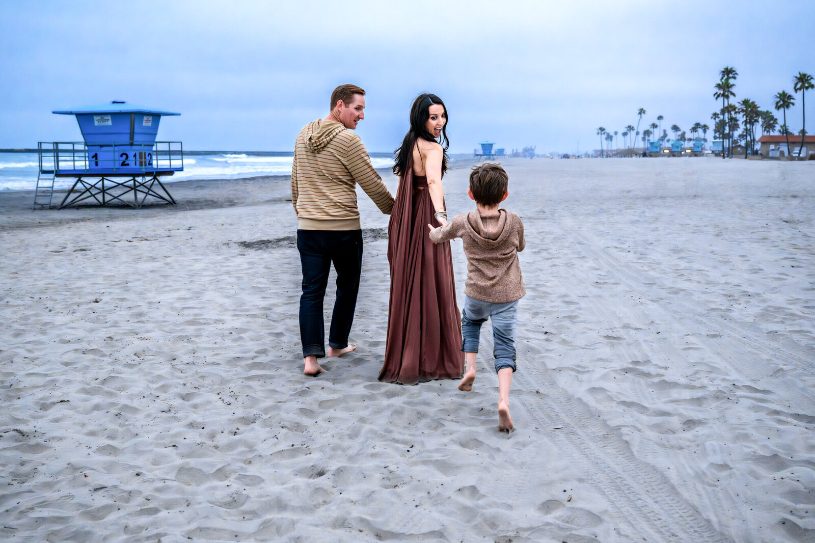 running to catch up to mom and dad at oceanside beach photos