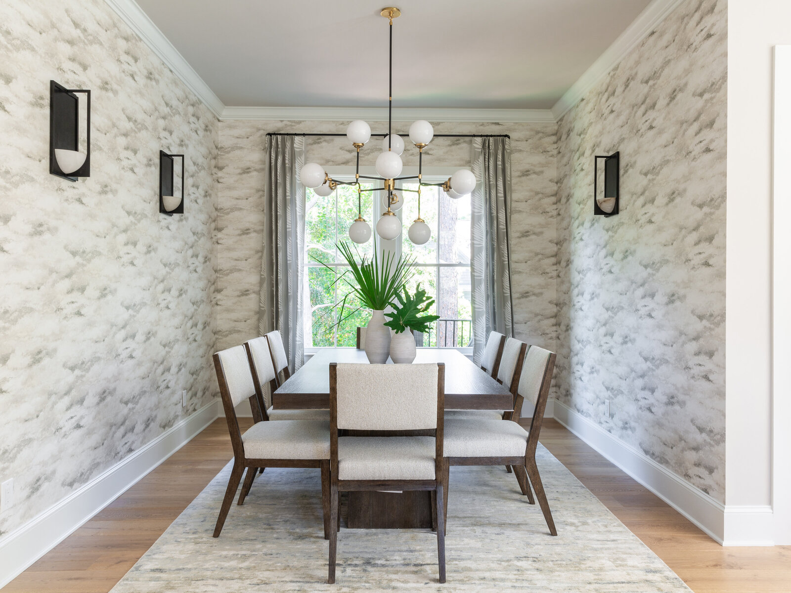Elegant dining room in Kiawah Island, SC, featuring textured wallpaper, a modern chandelier, and a neutral color palette for a sophisticated coastal interior design.