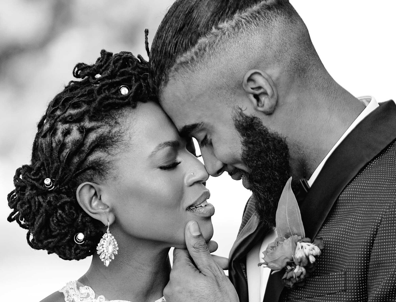 A  black couple in love bows their heads together on their wedding day