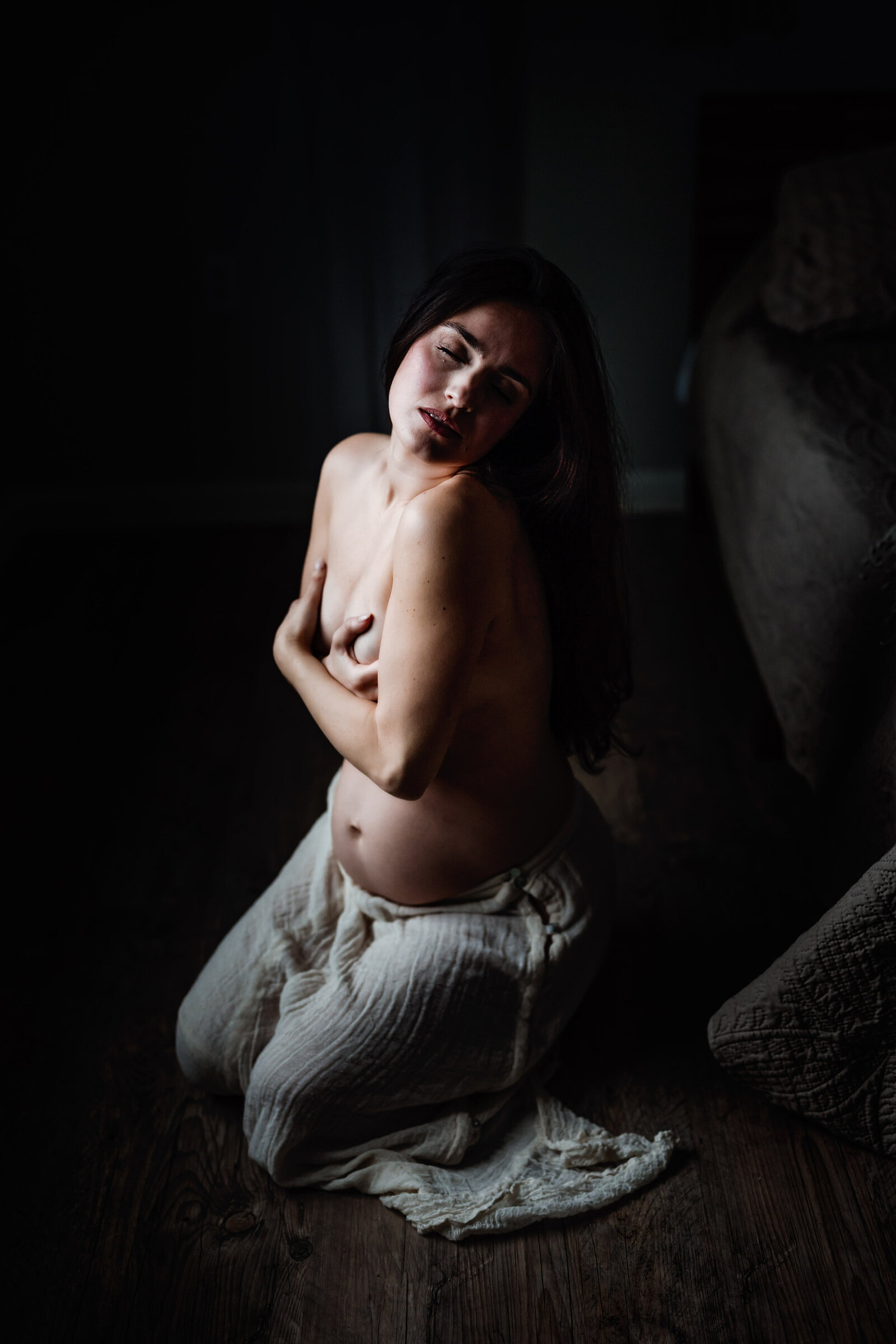 Pregnant woman kneeling in the window light in Florida