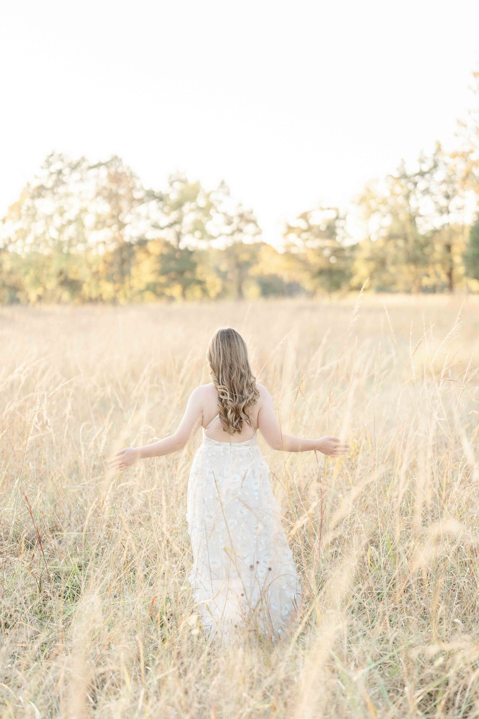 girl playing with the tall grass during Ashburn, VA senior picture