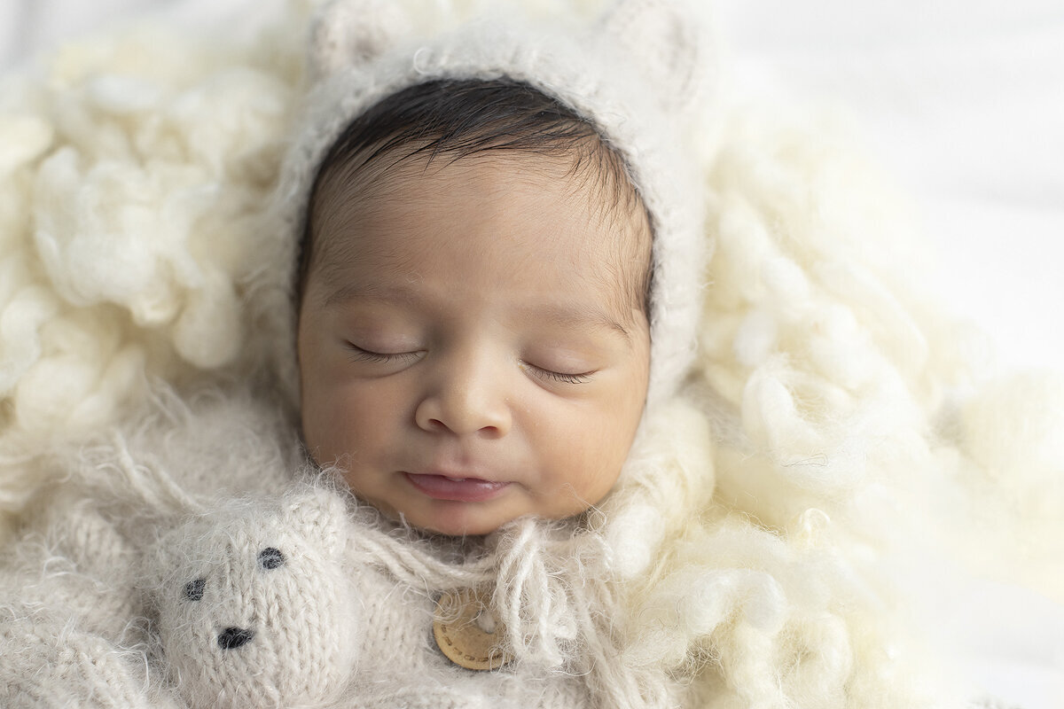 Newborn boy dressed as a teddy bear.
