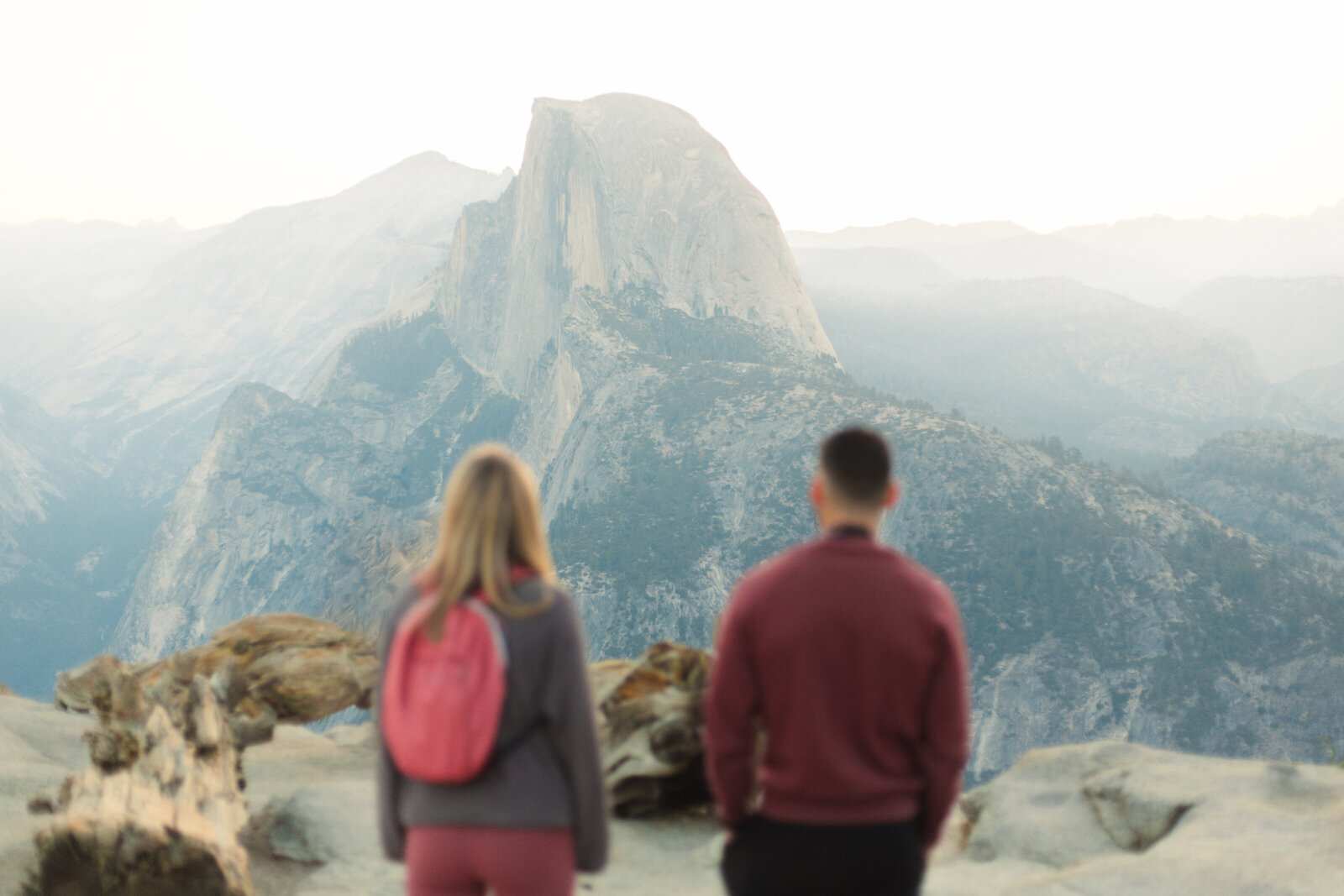 A wedding proposal between two hikers at sunrise in front of Half Dome in Yosemite National Park.