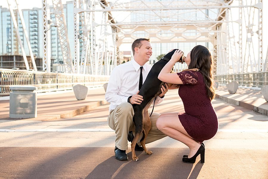 Couple wearing formal wear and walking their dog on the pedestrian bridge in Nashville