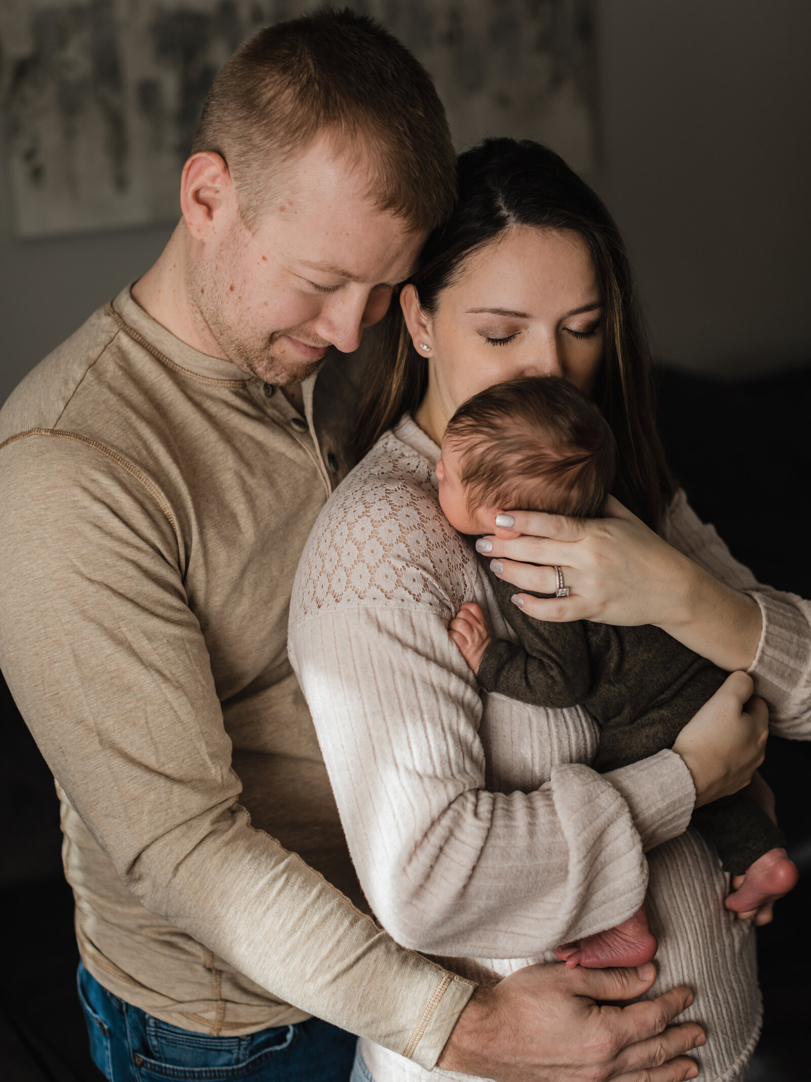 mom and dad holding newborn baby boy for in home lifestyle photoshoot