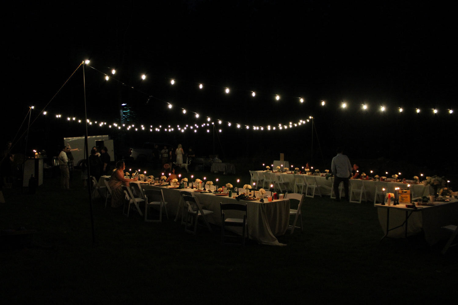 Evening outdoor dinner with string lights illuminating tables