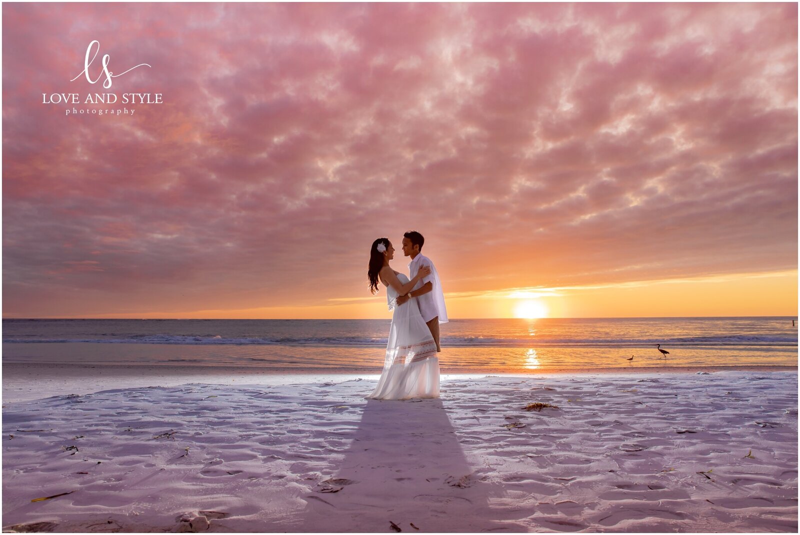 Engaged couple backlit against the sunset on Coquina Beach