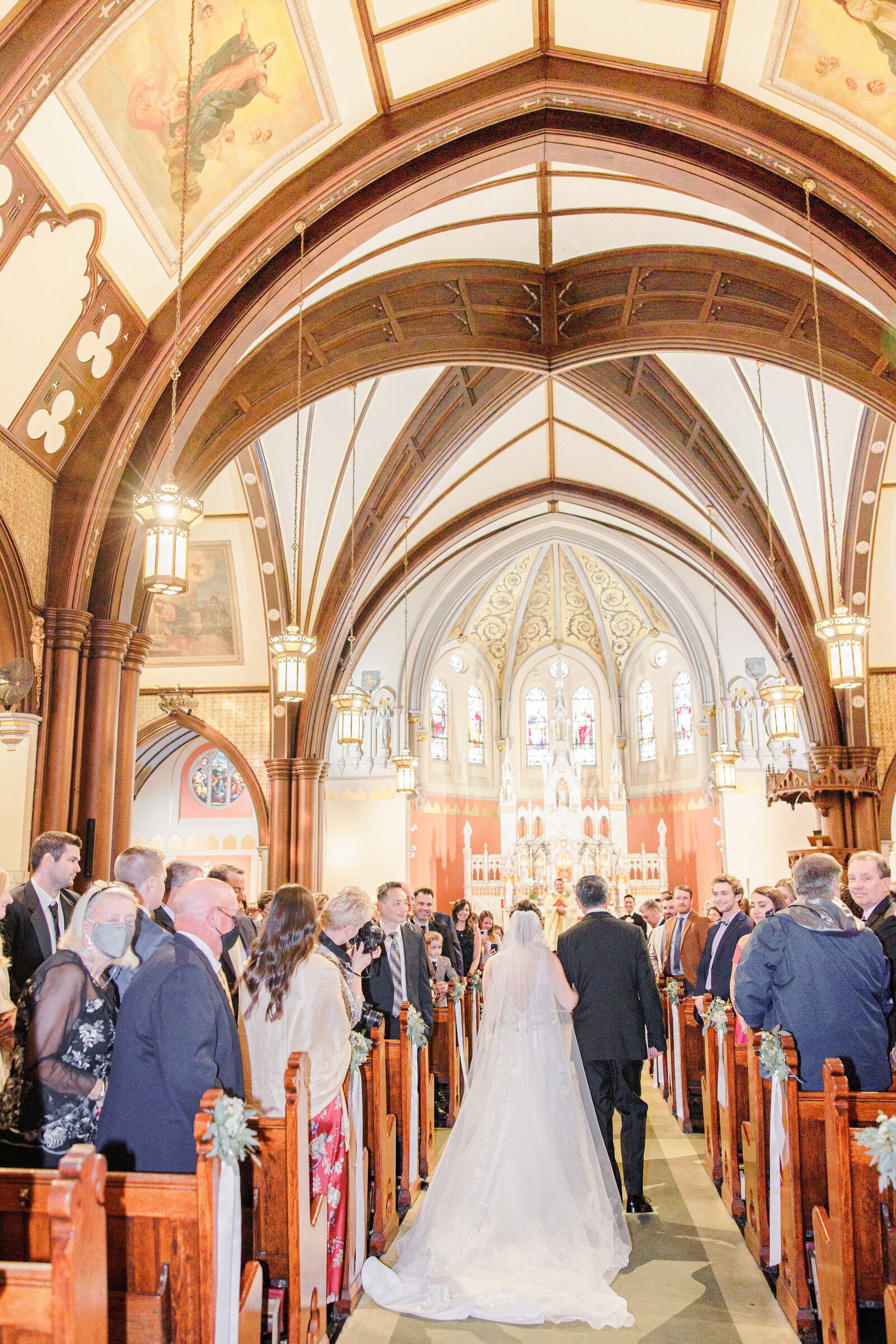 Bride and father walking down the aisle in church Boston