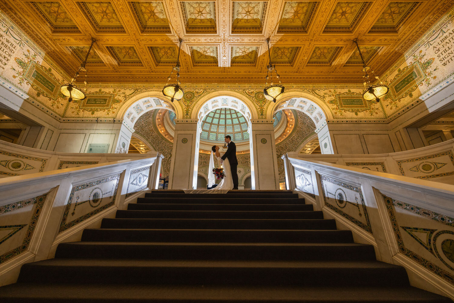 A bride and groom are dancing on the stairs of a building.