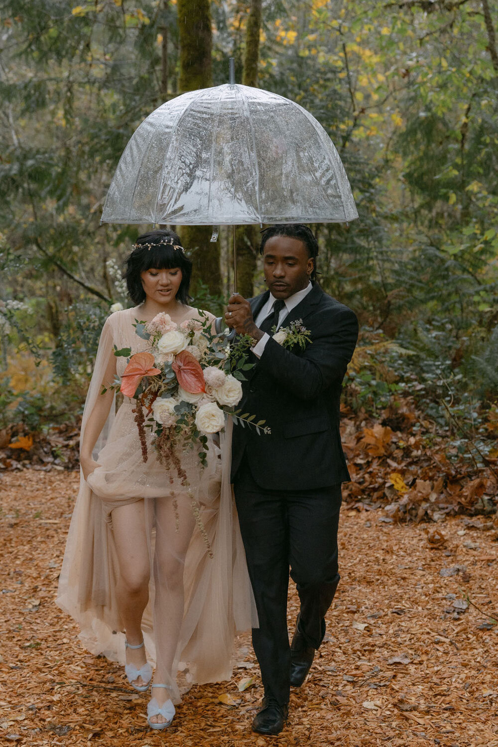 bride and groom under clear umbrella