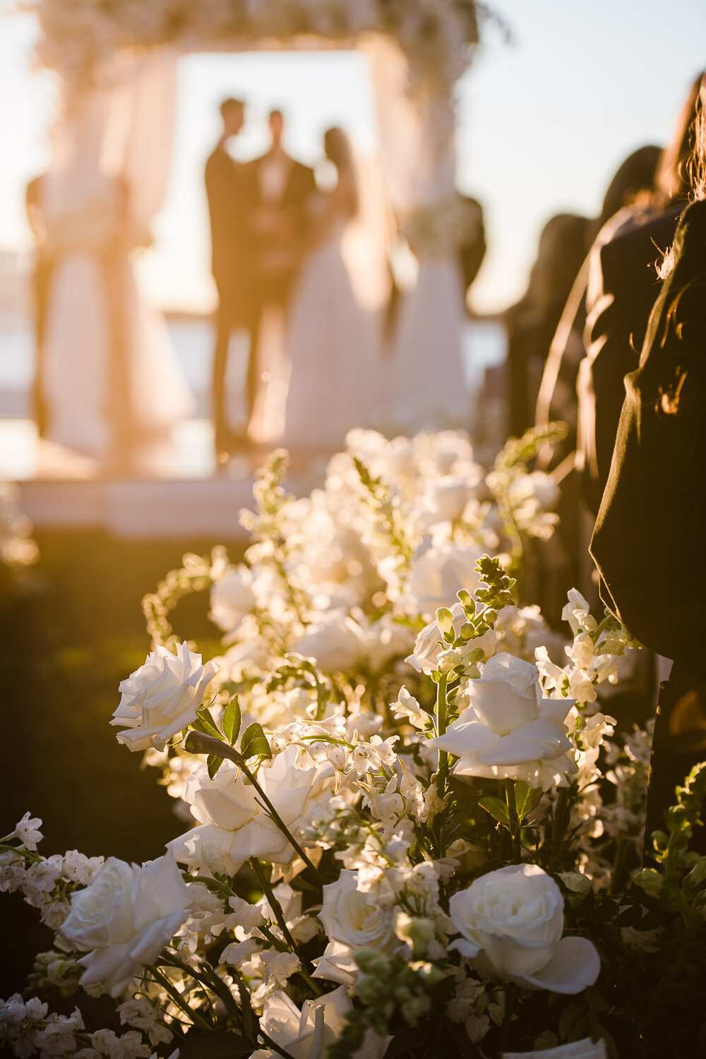 sunlit ceremony decor with out of focus bride and groom