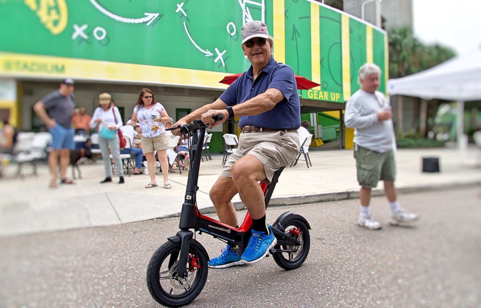 Man on Red Go-Bike M3 with stadium in the background