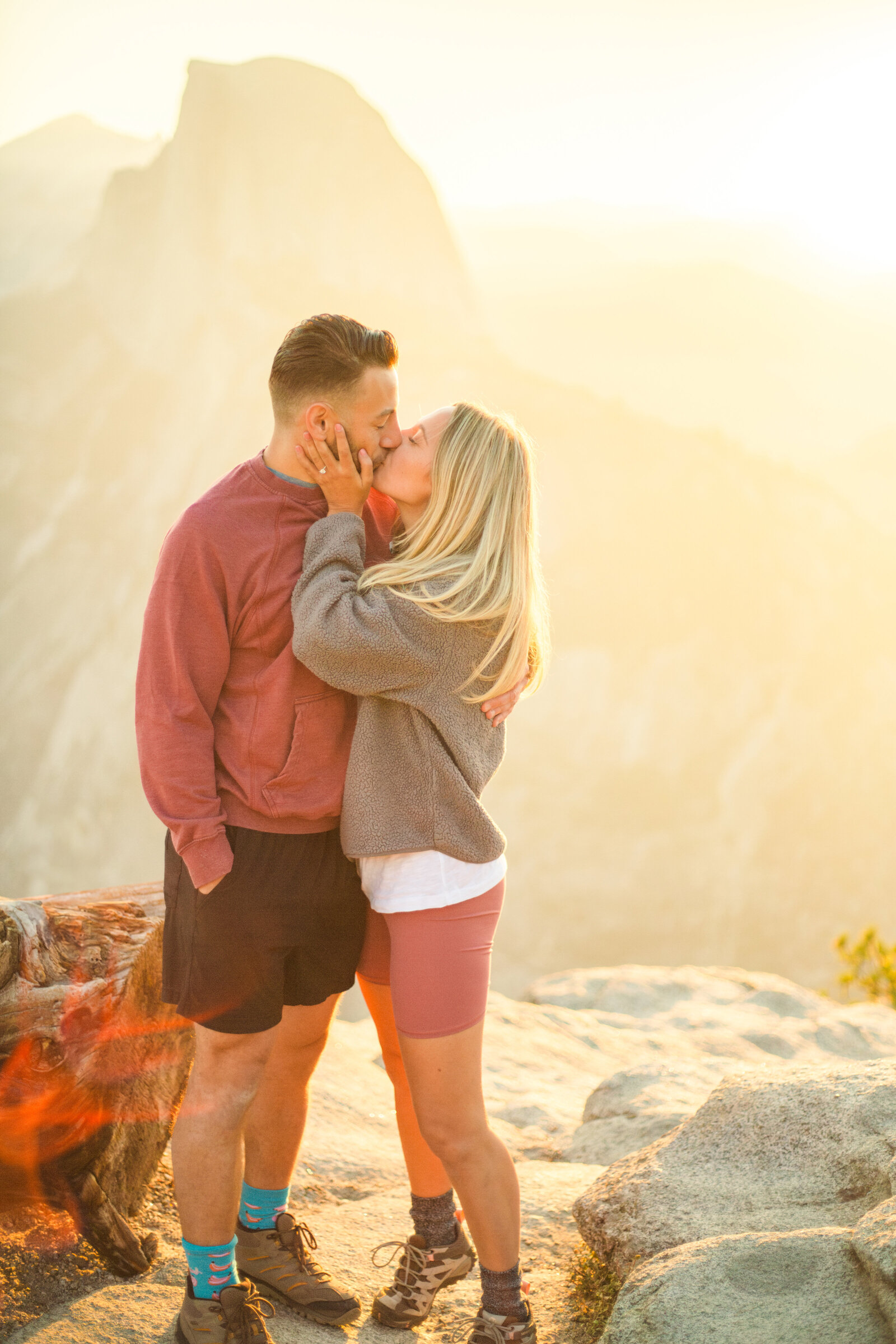 A wedding proposal between two hikers at sunrise in front of Half Dome in Yosemite National Park.