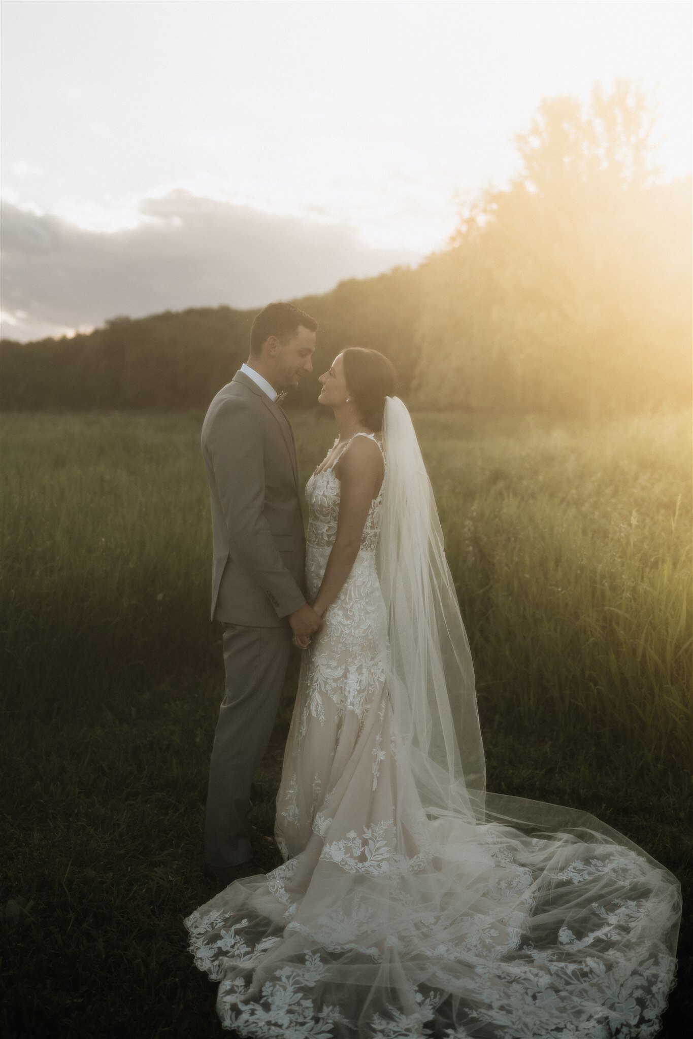 A film wedding portrait at sunset of bride and groom connecting