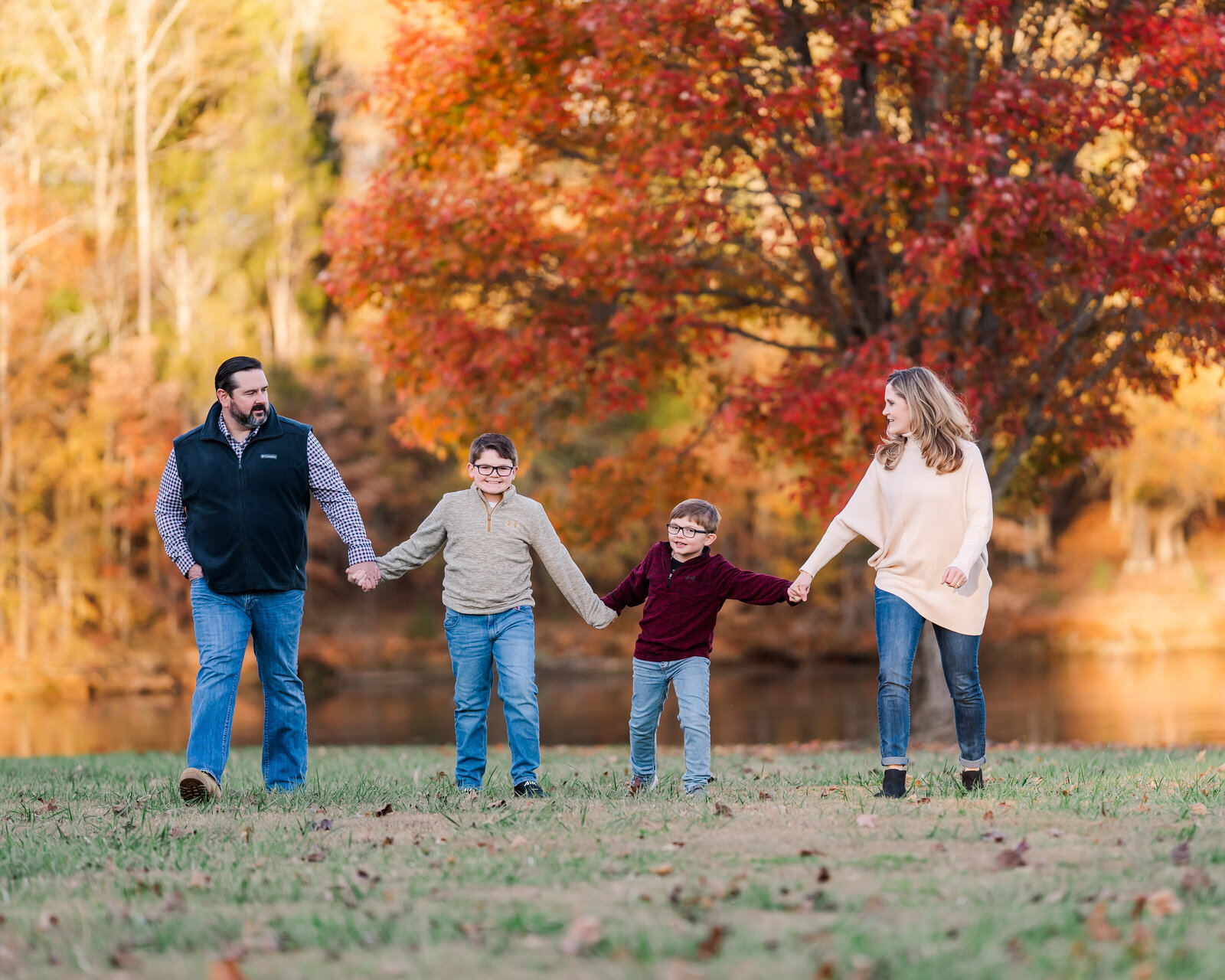 Family walks in the leaves together in the fall