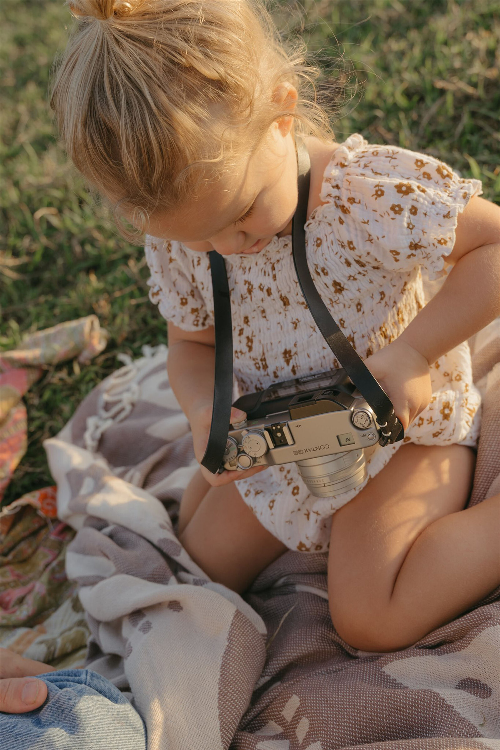 Styled Maui family photography session on a cliffside, capturing play and connection in denim and neutral tones.
