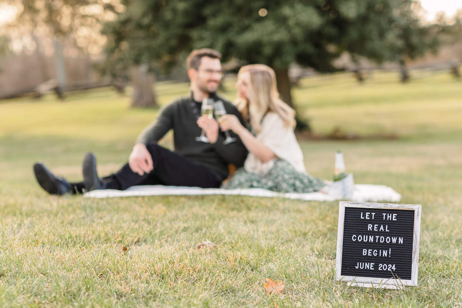 A couple celebrating their pregnancy with a sign announcing their baby.