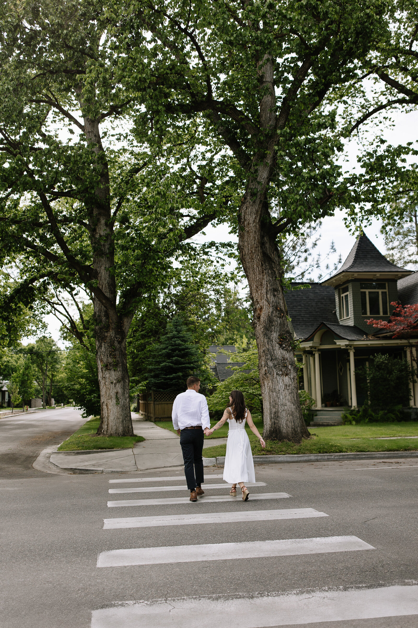 Eloping couple running across empty street in downtown Coeur d'Alene, Idaho