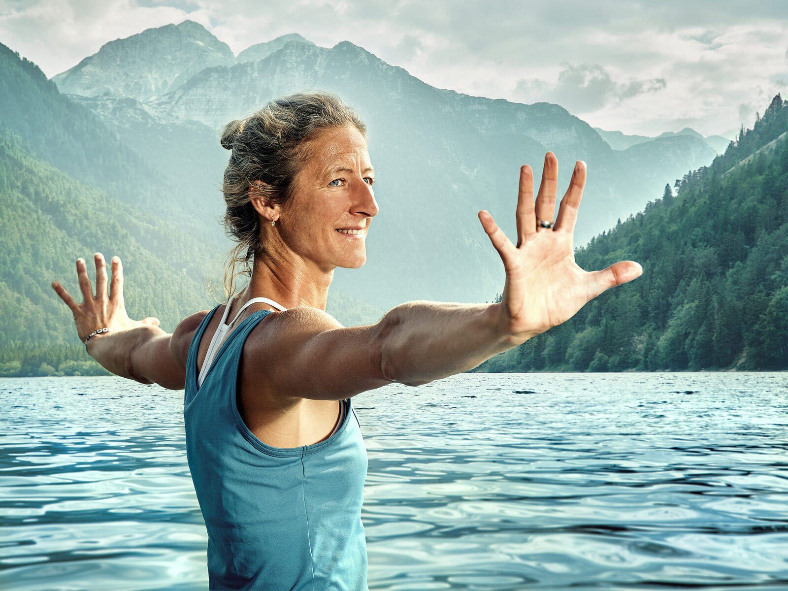 Authentische Outdoor-Aufnahme einer Frau bei Achtsamkeitsübung am Bergsee – visuelle Konzepte für Marken mit Naturbezug