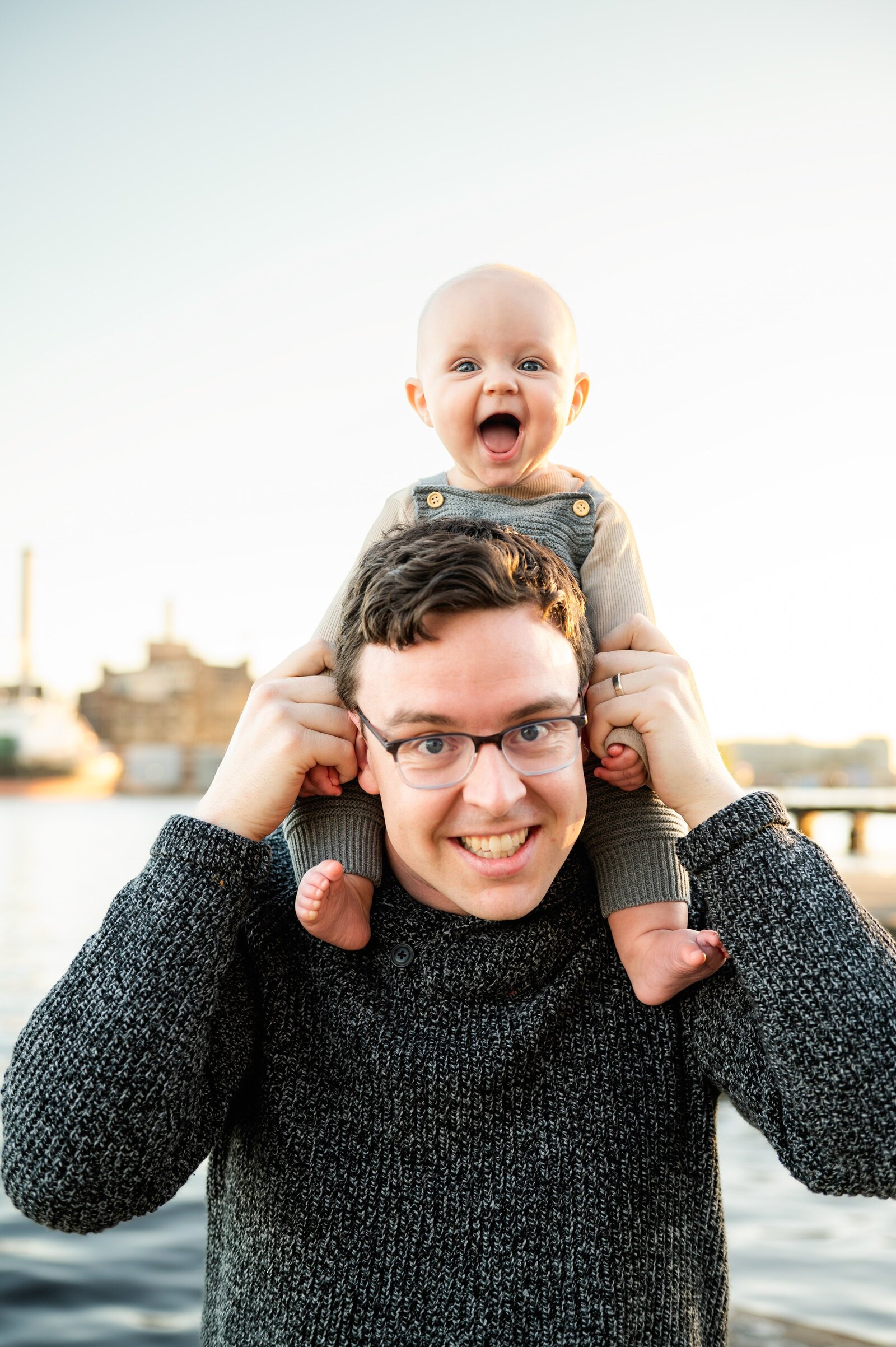 baby on dads shoulders as he smiles