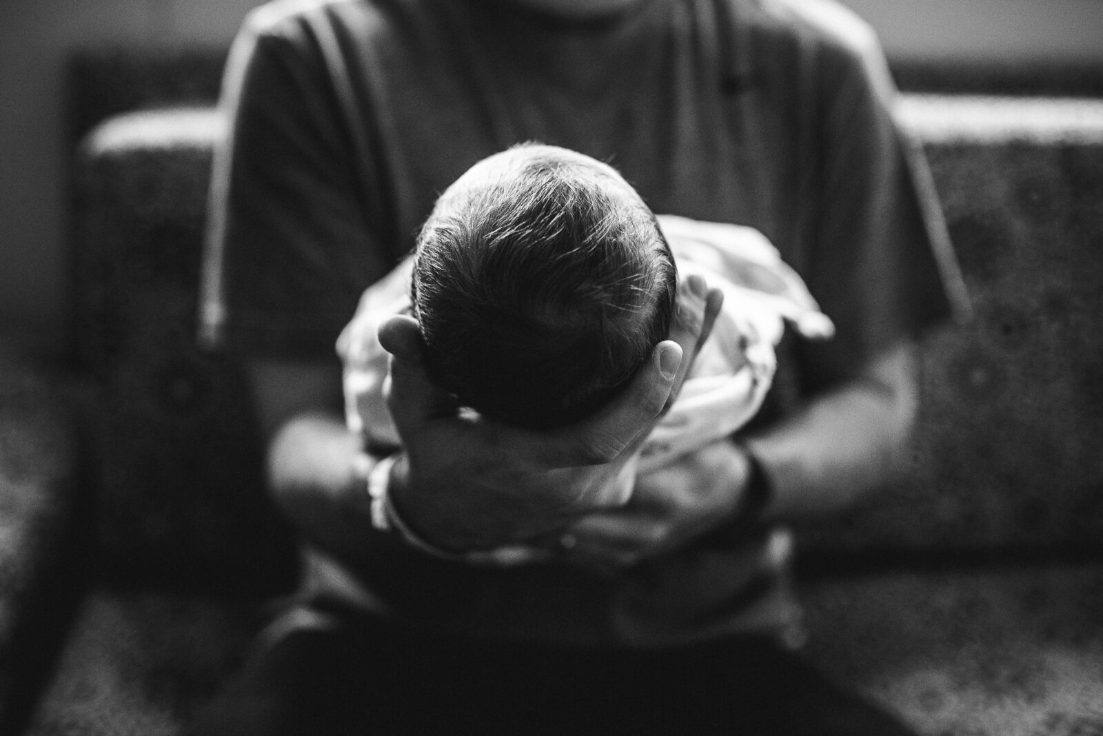 black and white of dad holding new baby