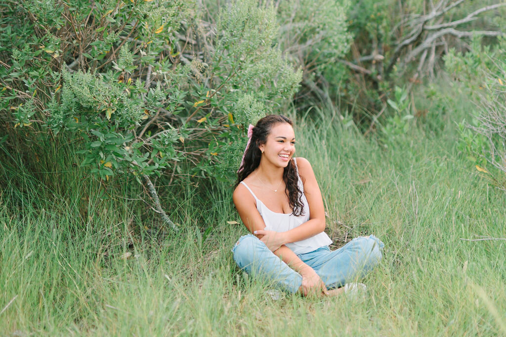 a young woman sitting in the grass