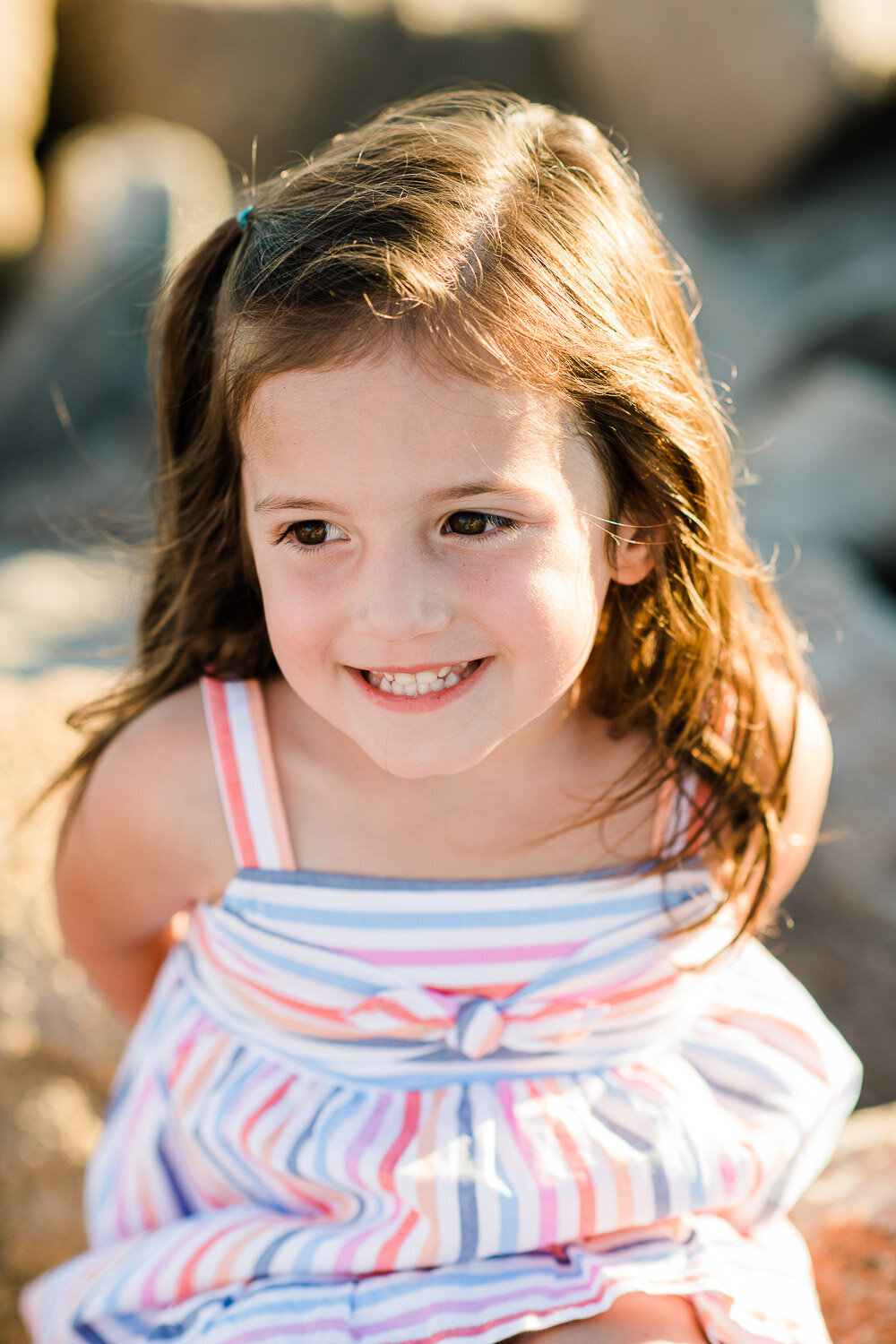 young girl in sunlight on rocks