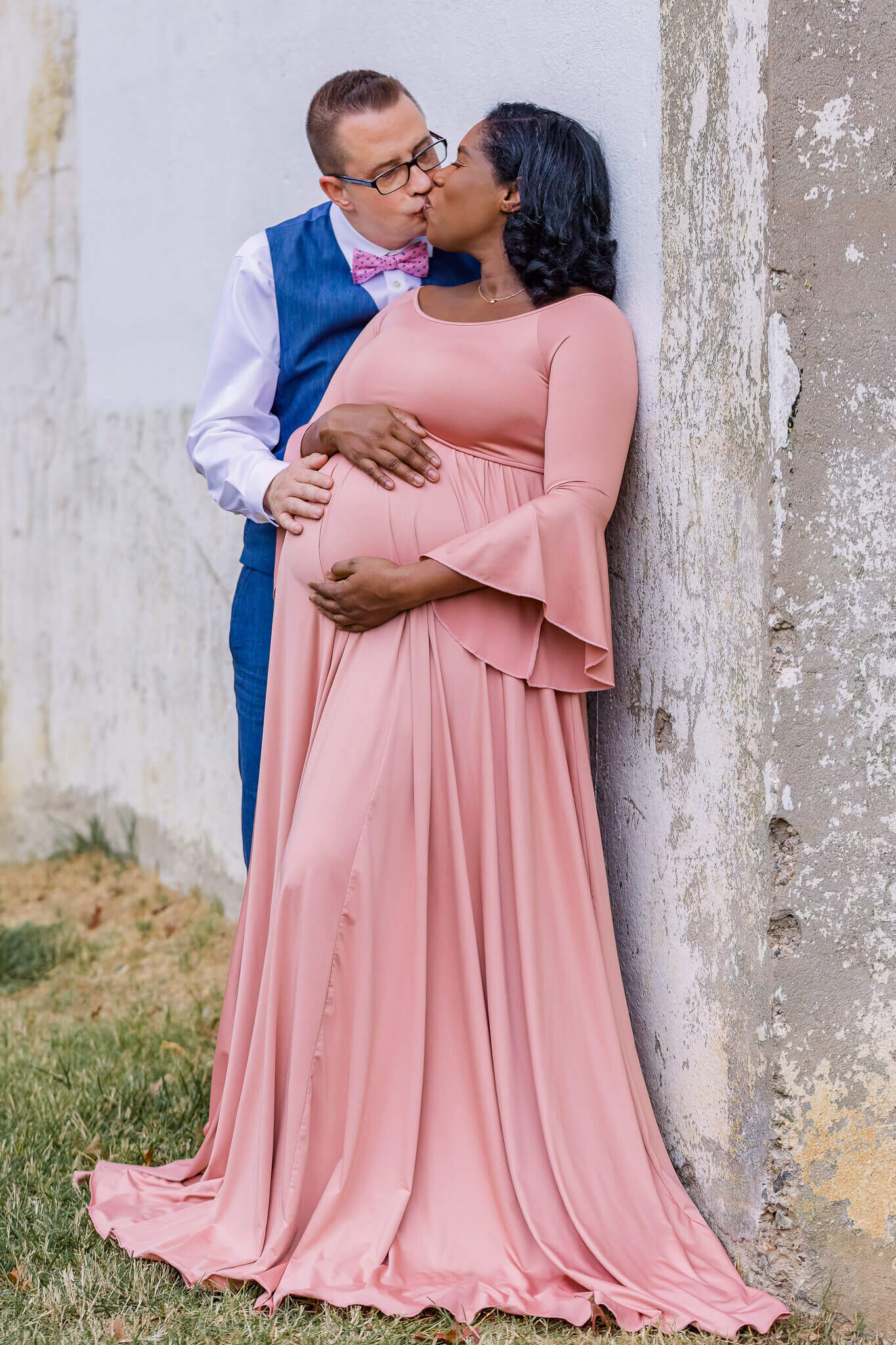 A happy couple embracing her pregnant belly during a maternity session.