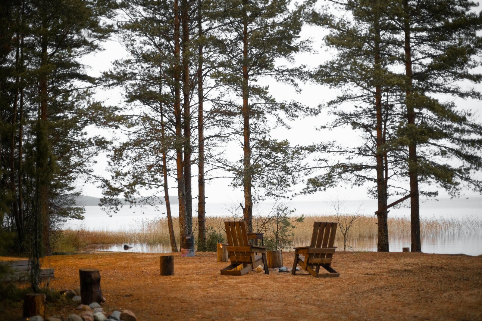 Image of two empty chairs at a campsite next to a pond