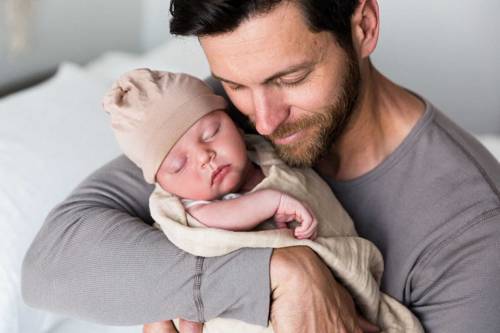 dad holding newborn baby closely