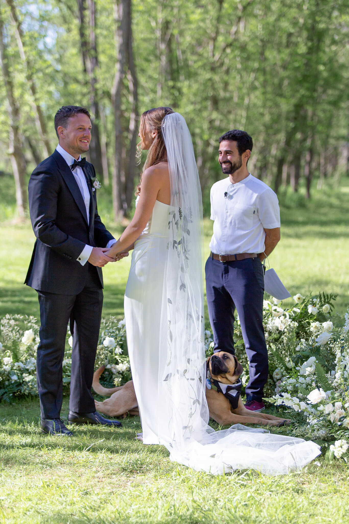 A bride and groom stand hand-in-hand on their wedding day during their ceremony near Raleigh NC.