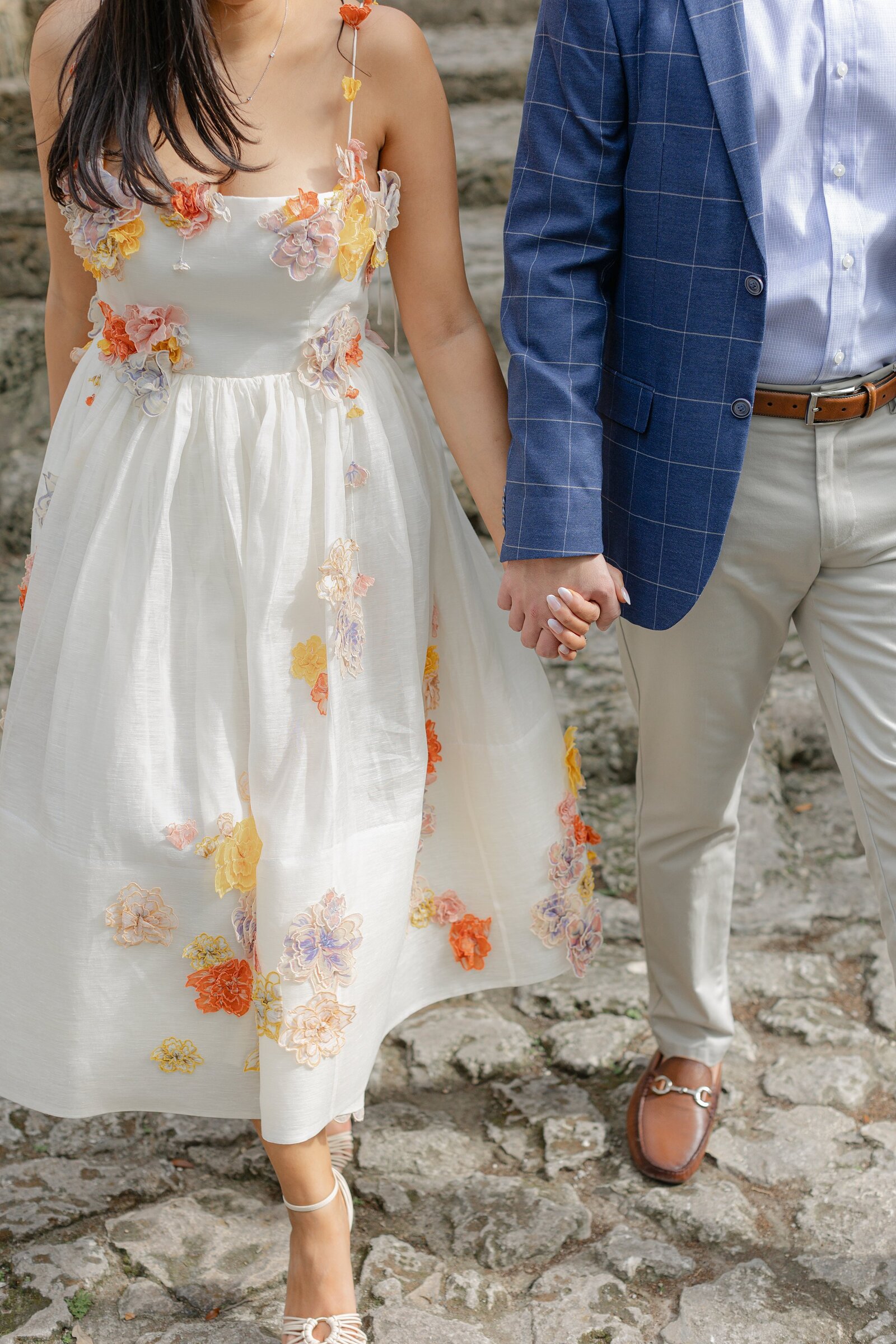 Couple walk hand in hand down stone steps at Vizcaya Museum Miami.