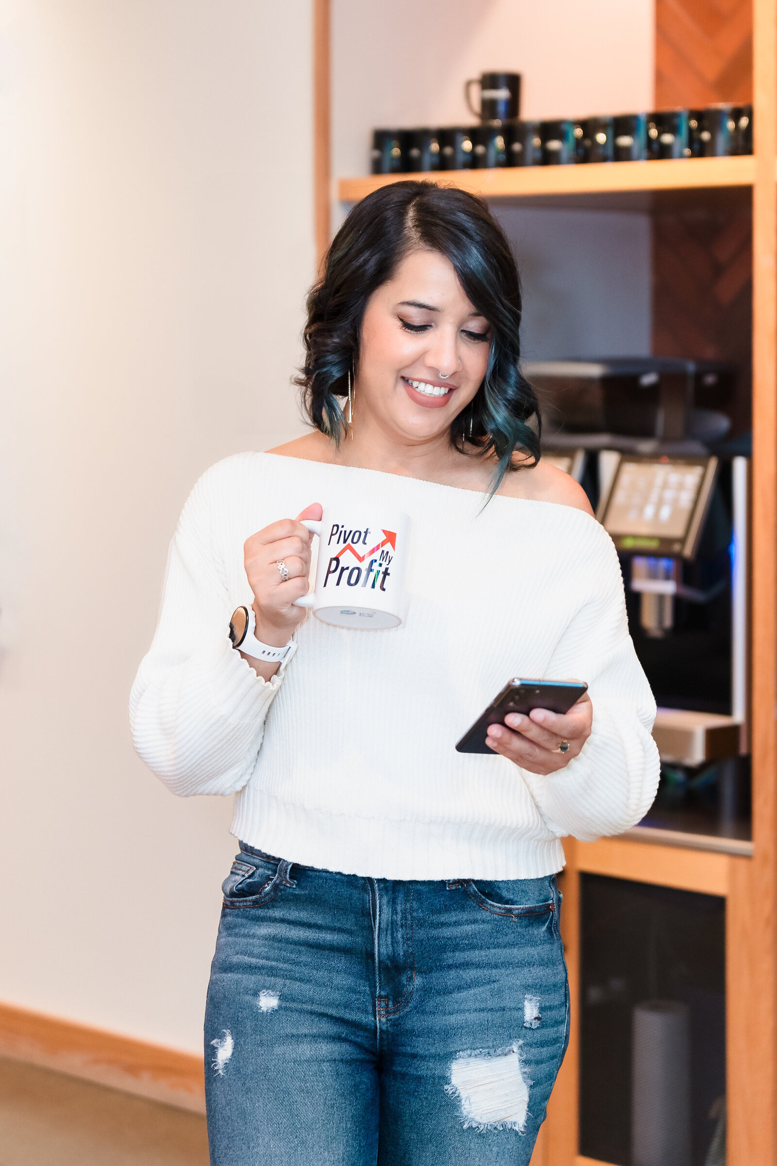 Business Coach checks her phone and holds a coffee mug