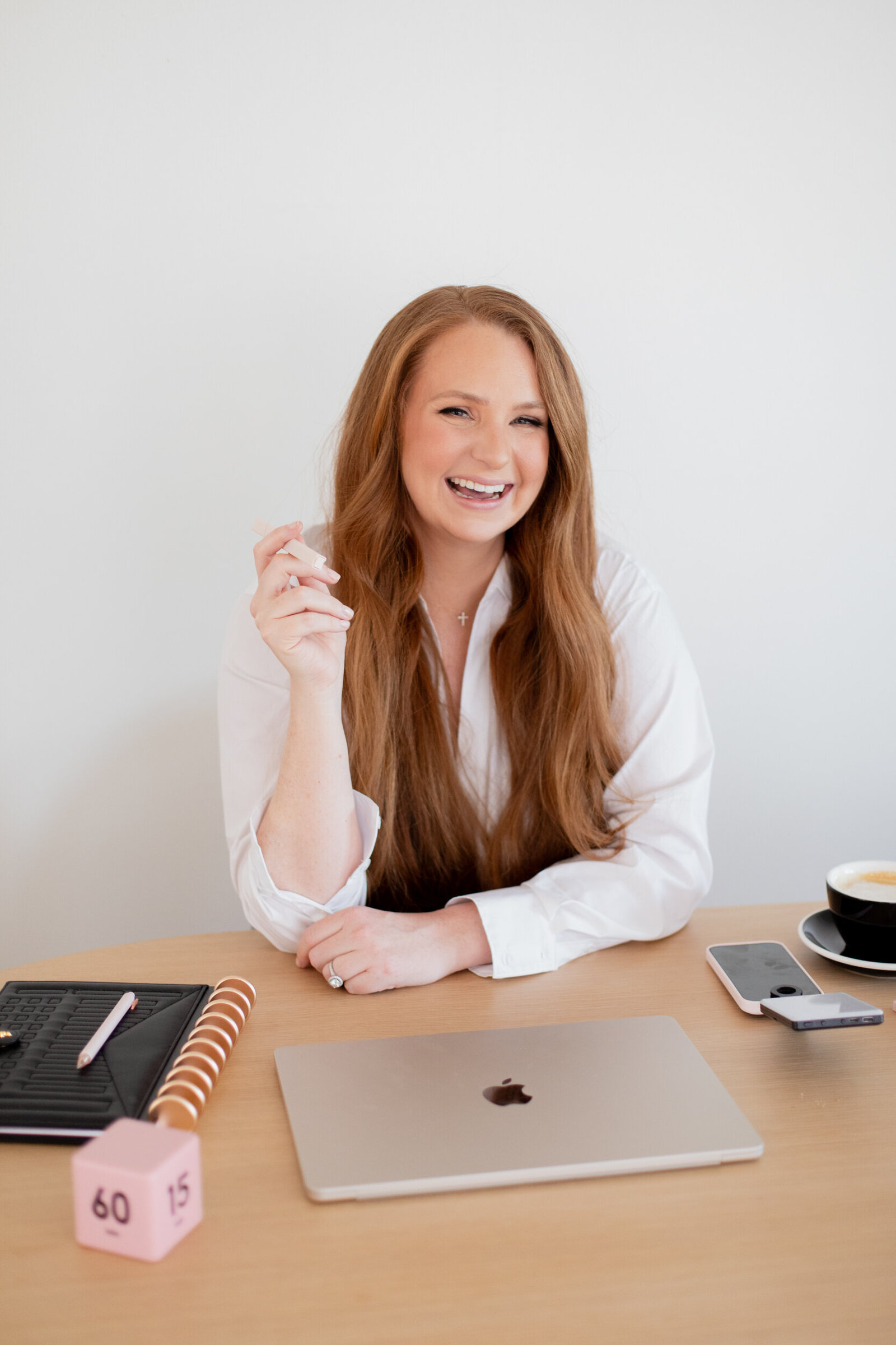Kristina at her desk with her laptop, laughing