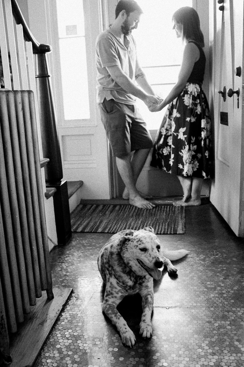 dog laying down with couple holing hands in background
