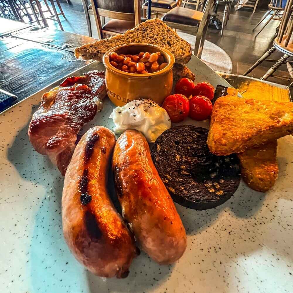 Full English Breakfast, sausages, bacon, egg, black pudding, hash browns, tomatoes, baked beans and toast.