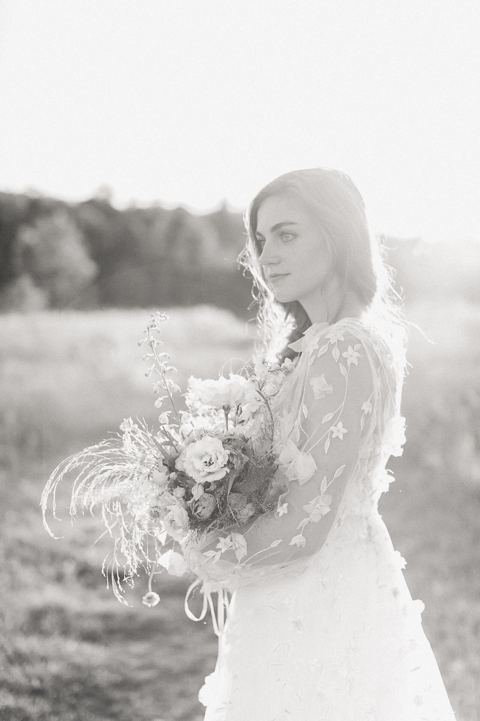 Black and white image of a bride during sunset by wedding photographer in Maine Emi Rose Studio