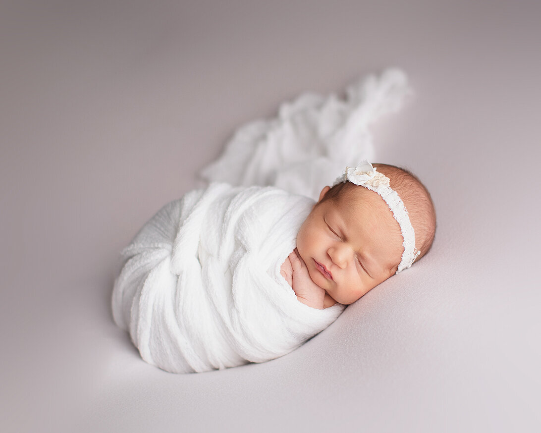 baby wrapped in white