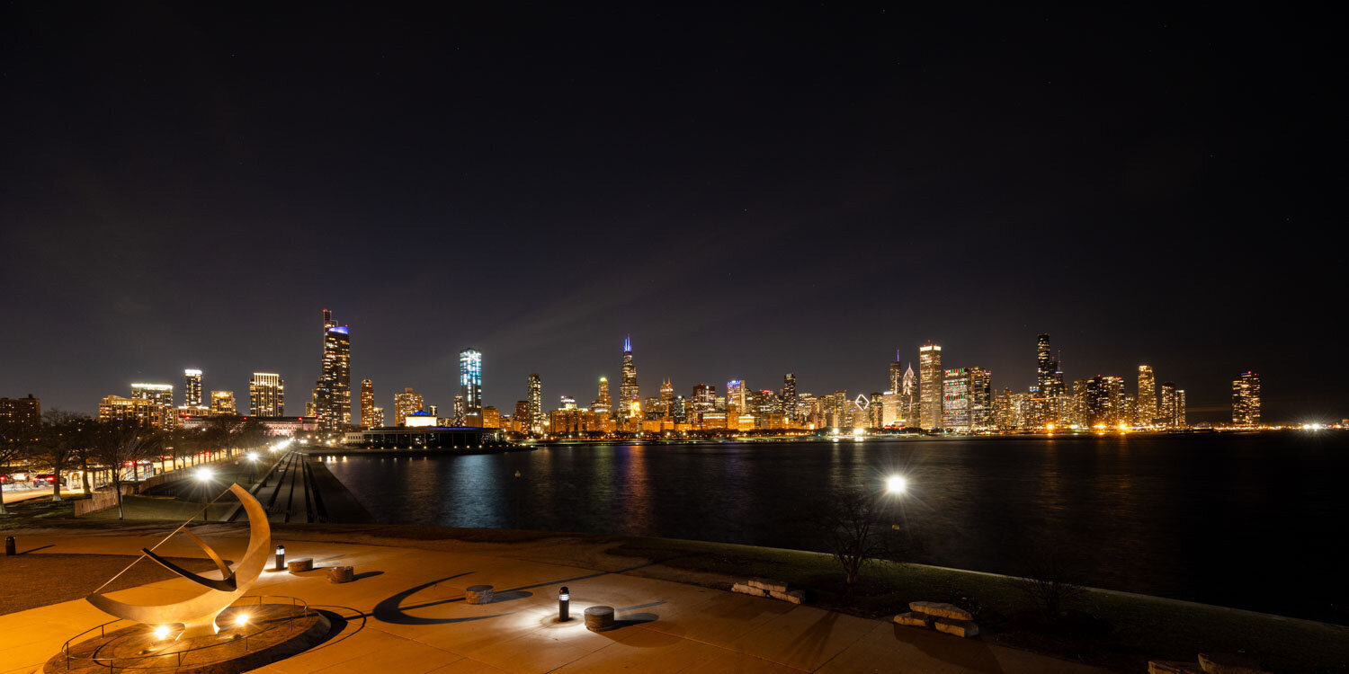 Nighttime city skyline across a waterfront