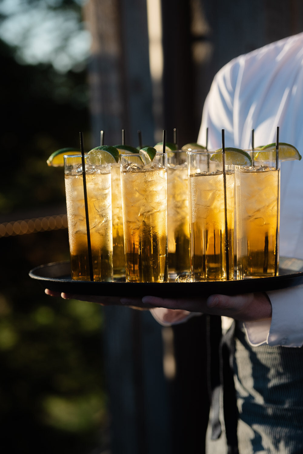 tray of golden cocktails with limes