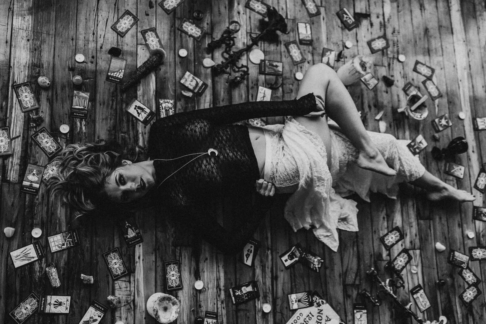 woman laying on the floor with tarot cards around her