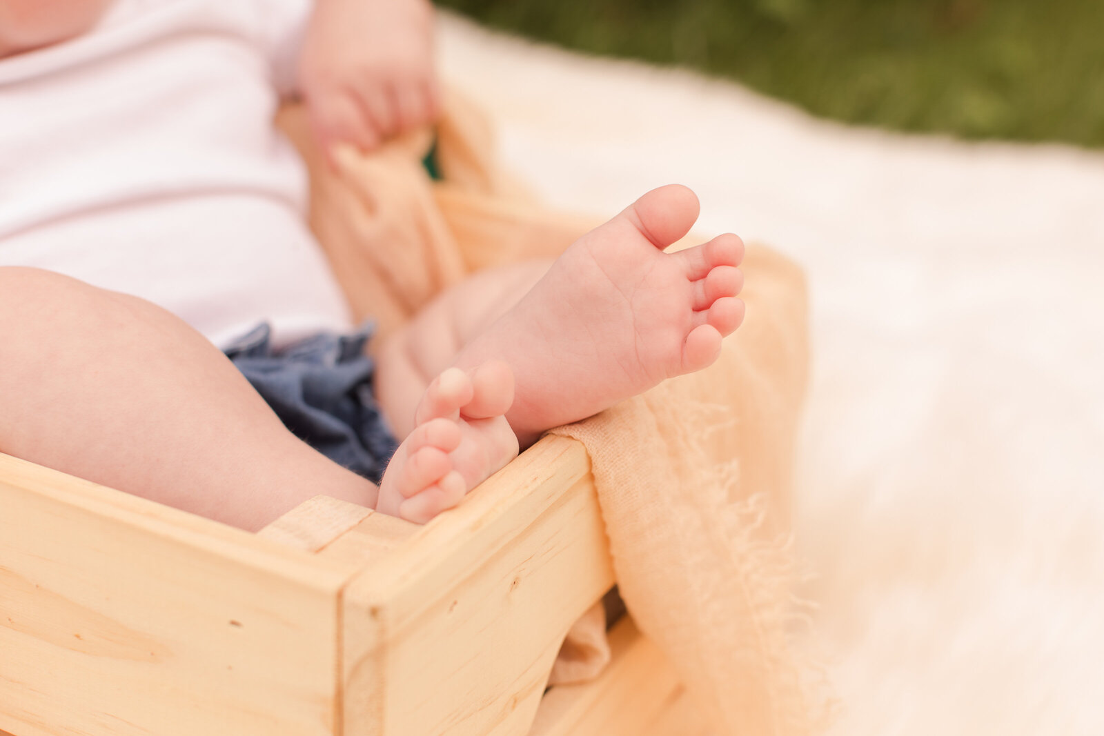 baby in a wooden crate close up of feet