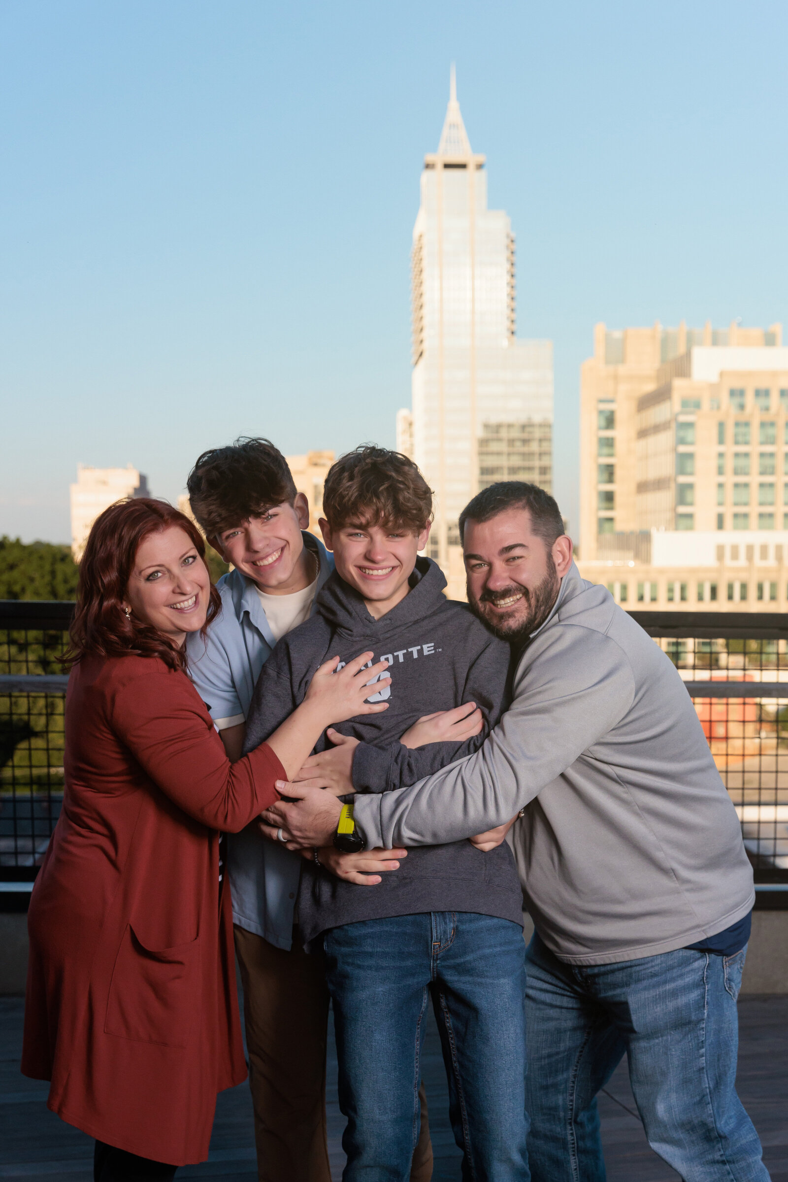 Hug your senior at the end of their senior session with the Raleigh skyline.